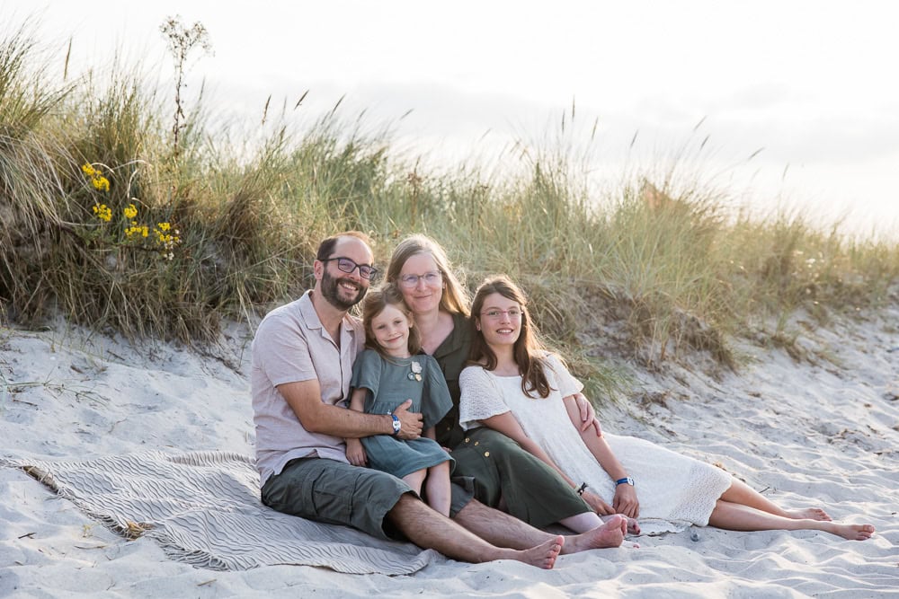 eine vierköpfige Familie sind am Strand im Sand vor den Dünen, fotografiert in Schönberg an der Ostsee