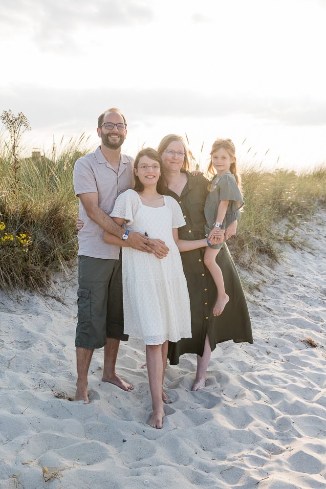 eine vierköpfige Familie sind am Strand im Sand vor den Dünen, fotografiert in Schönberg an der Ostsee