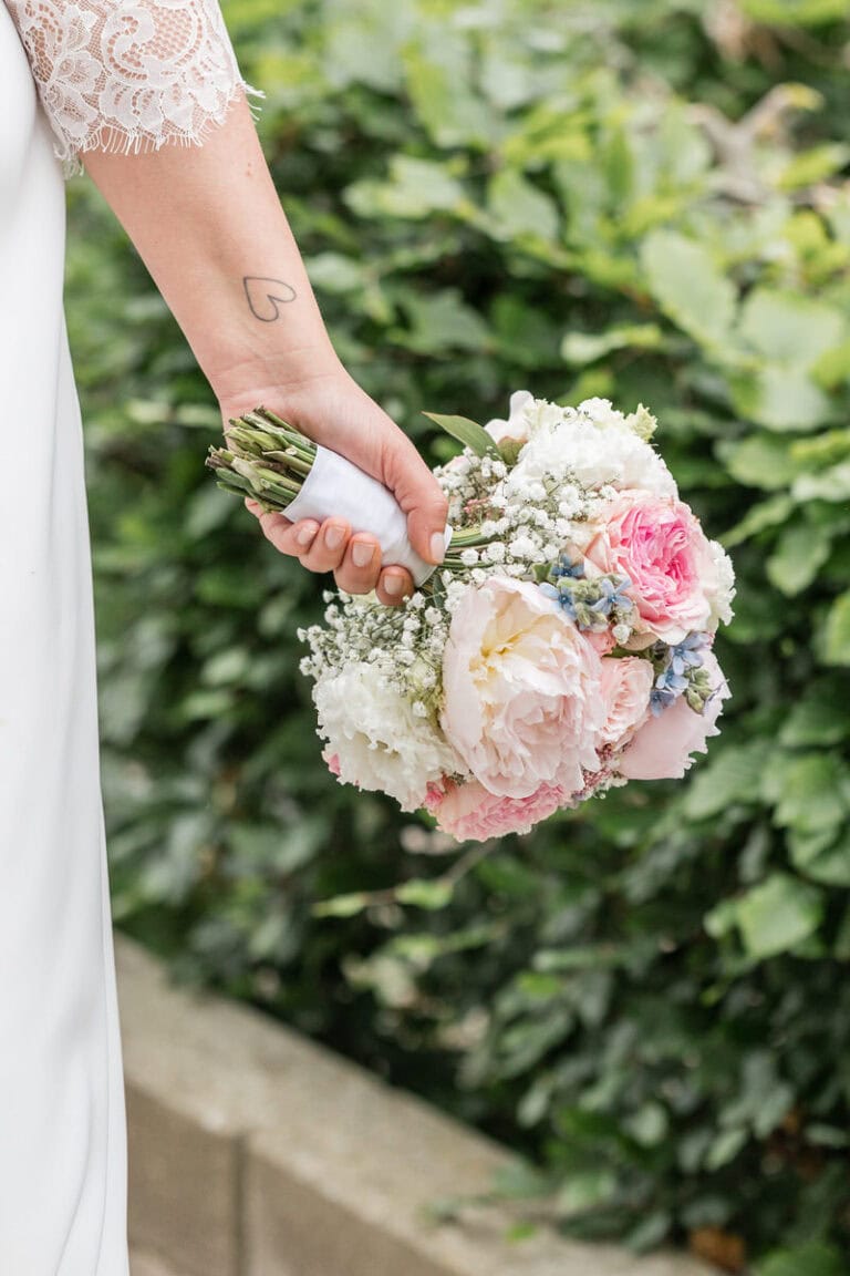 Braut hält einen bunten Hochzeitsstrauß bei der standesamtlichen Hochzeit.